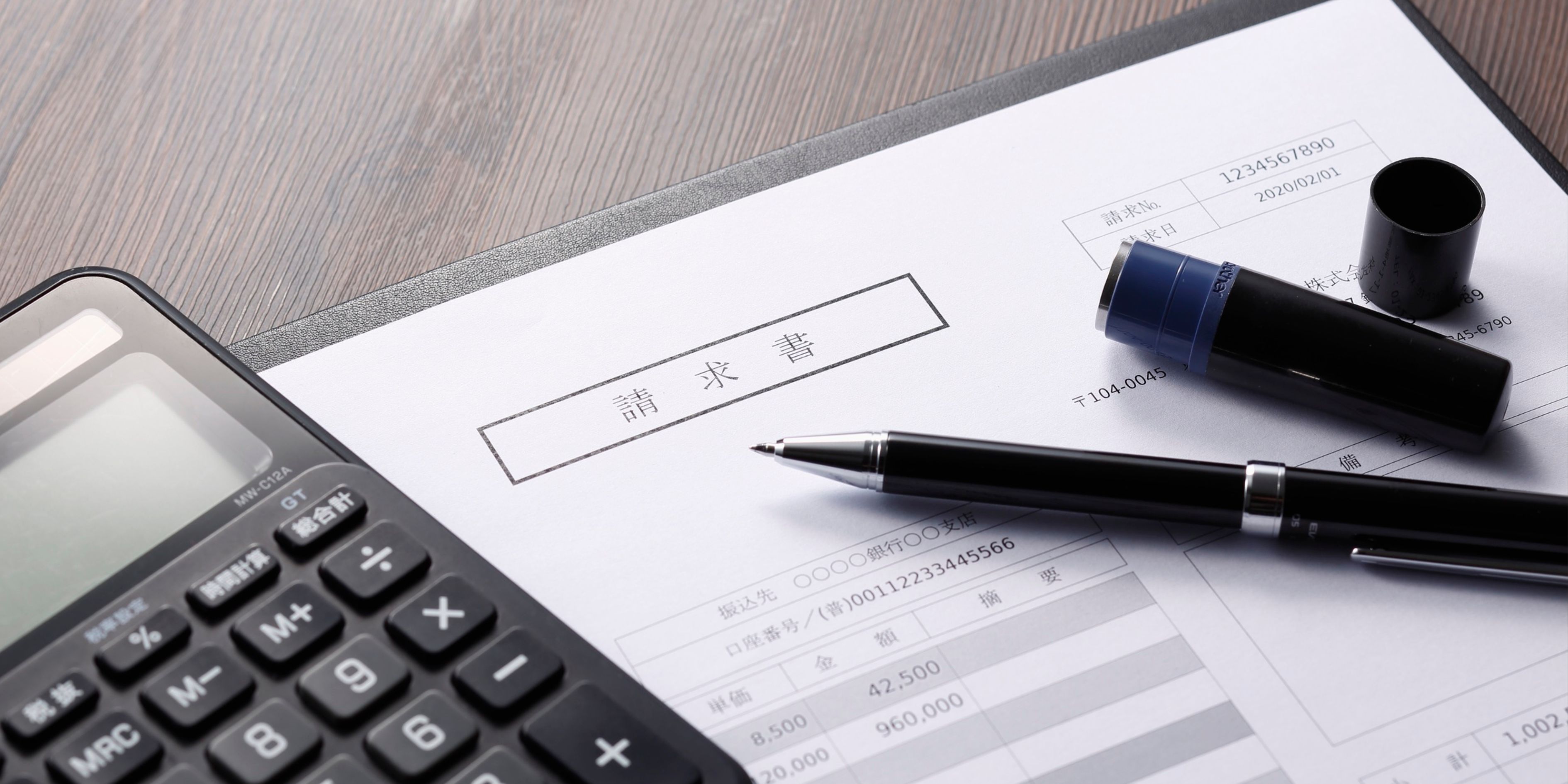 calculator, pen ,and an invoice on a table